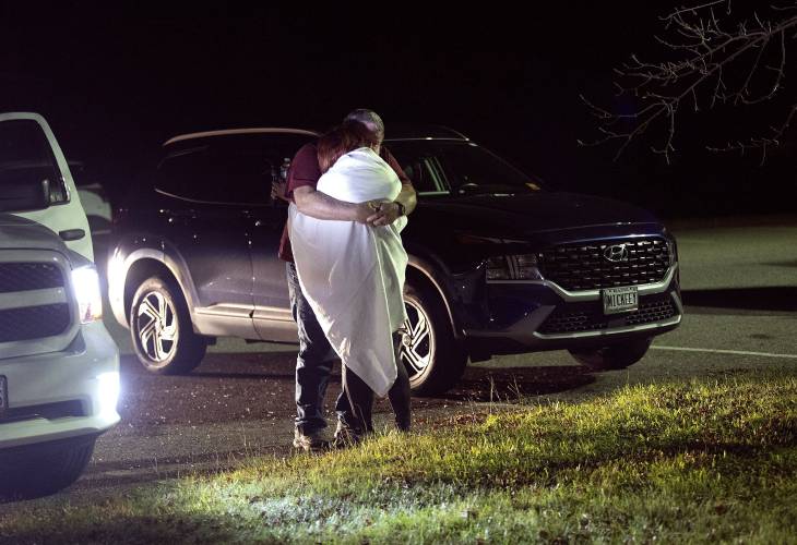 A woman is hugged by a man at a reunification center at Auburn Middle School, in Auburn, Maine, after shootings in Lewiston on Wednesday, Oct. 25, 2023. (Derek Davis/Portland Press Herald via AP)