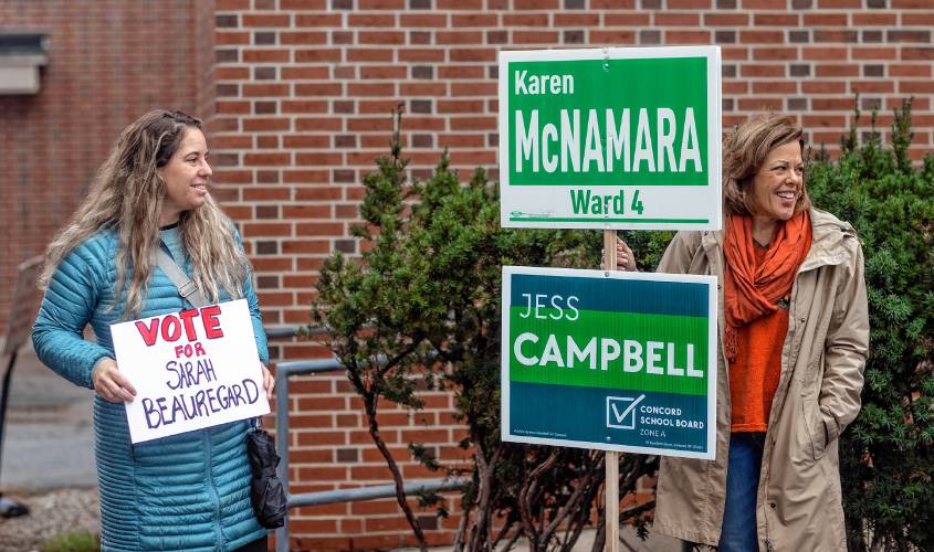Candidates Sarah Beauregard (left) and Karen McNamara hold signs outside the Ward 4 polling place at the Green Street gym on Tuesday, November 7, 2023.