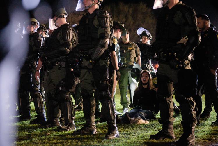 Dartmouth College student Maya Beauvineau, continues to sing a protest song she was leading when New Hampshire State Police in riot gear arrested her in Hanover, N.H., on Wednesday, May 1, 2024. Beauvineau was participating in a protest of the Israel-Hamas War during which students set up tents on the College Green in violation of university policy. (Valley News - James M. Patterson) Copyright Valley News. May not be reprinted or used online without permission. Send requests to permission@vnews.com.