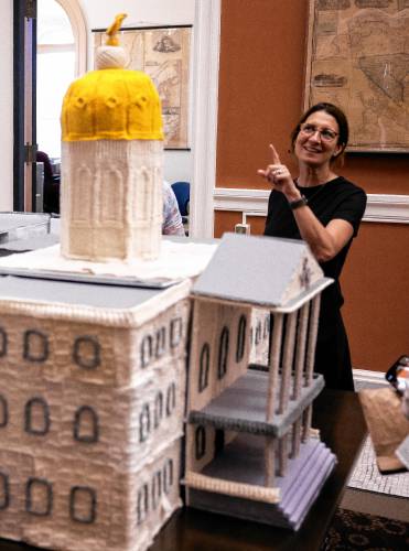 Kara Mollano, a teacher at Second Start, poinyd up at the Knit Democracy Together State House knitting model at the New Hampshire State Library on Thursday, June 13, 2024. The project was part of a intitiative from New Hampshire Humanities and the National Endowment for the Humanities.