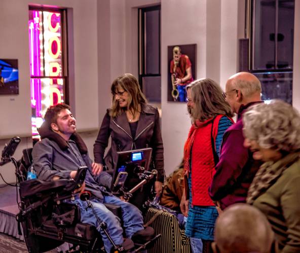 Samuel Habib and his mother, Betsy McNamara (center), greet people that came to the premiere of his film “The Ride Ahead,” at the Bank of NH Stage in Concord on Monday. Habib directed the film along with his father, Dan Habib.