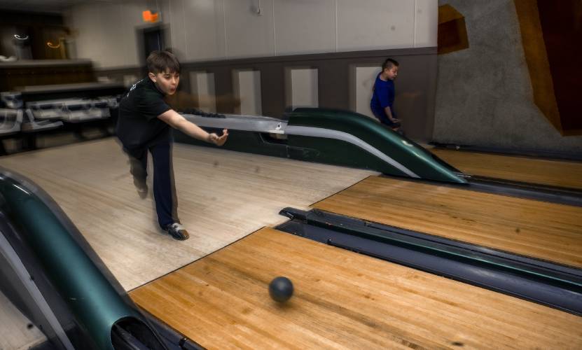 Patrick Douglas-Conlon (left), 11, bowls with his brother, Liam, at Boutwell’s on Friday. Twenty-four teams from the Northeast and Canada will be coming to Boutwell’s Bowling Center in Concord this weekend.