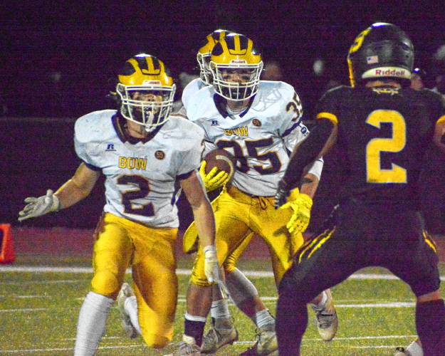 Bow's Caleb Schumacher (2) looks to block Souhegan’s JJ Bright (right) as teammate Gavin McCabe (35) runs with the ball during a Division II quarterfinal game on Friday night in Amherst. Souhegan won 54-6.