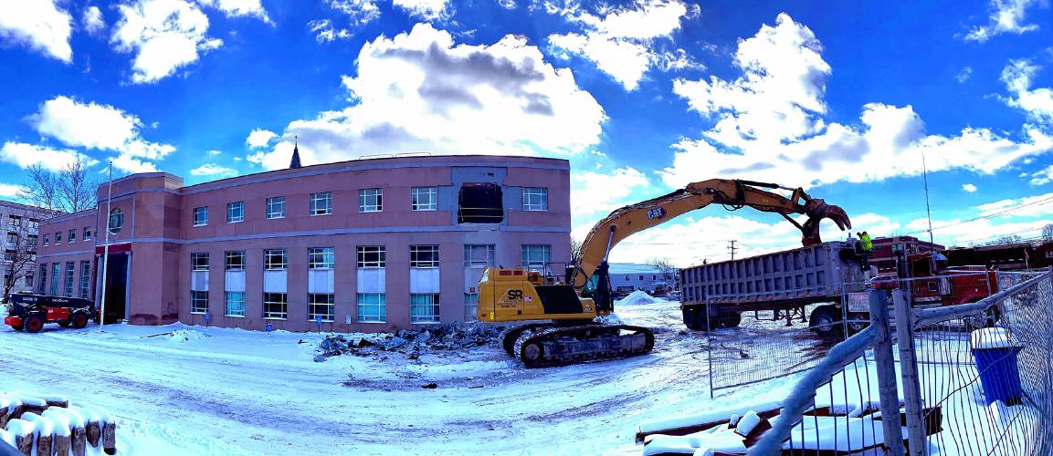 An excavator removes debris from the former Department of Justice building off of Capitol Street in Concord as the demolition of the building started on Wednesday.