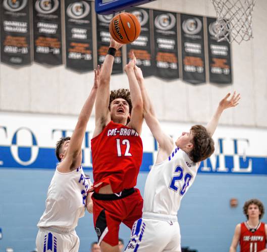 Coe-Brown center Quinn Salter goes up against two Pelham defenders during the second half of the Division II semifinal at Oyster River High School on Tuesday, March 5, 2024.