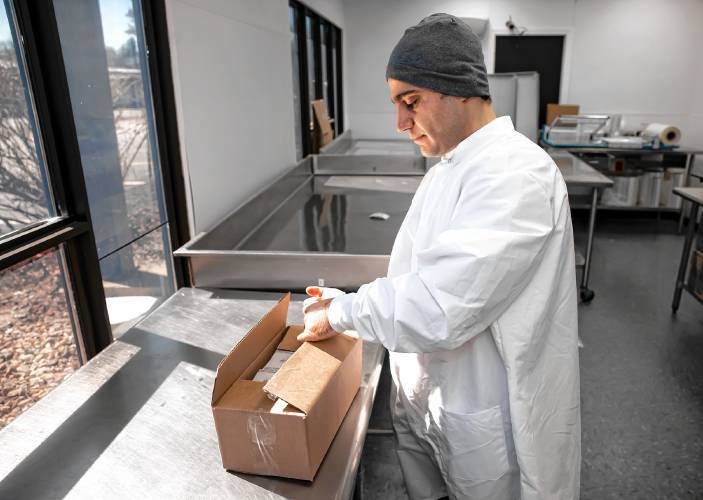Amhad Aissa packs up a box of custom made Aissa Sweets Coconut Chocolate Baklava that is shipped all over the world.