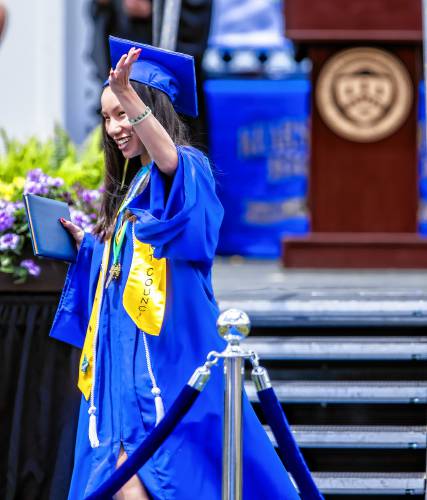 Kearsarge Regional High School graduate Caroline Gong Allen waves to her friends in the audience after receiving her high school diploma at the school on Saturday, June 8, 2024.