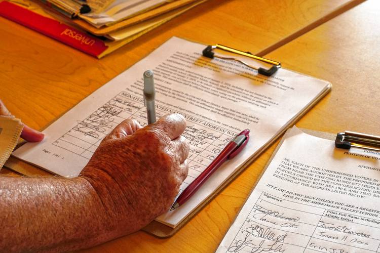 Lisa Stevens, an East Side resident, signing the Concord Concerned Citizens petition for a ballot question that would give voters power over where Concord puts its schools.