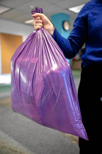 The purple trash bag did hold up better on the 20-pound test when held from the top opening.