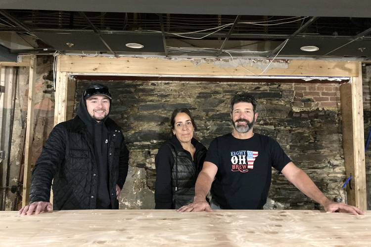 Jake Baraw, from left, Lisa Del Tufo and David Del Tufo stand inside their partially rebuilt bar Eight Oh Brew in Ludlow, Vt., Oct. 19, 2023, three months after severe flooding in the ski town. They hope to reopen by mid-December of 2023. (AP Photo/Lisa Rathke)