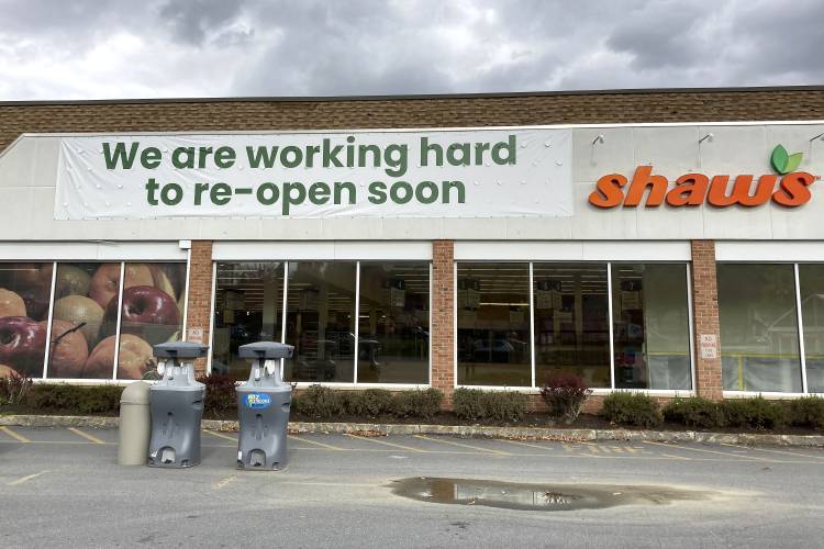 A sign is attached to the exterior of a closed grocery store, Thursday, Oct. 19, 2023, in Ludlow, Vt., three months after severe flooding hit the ski town. The store, which has not said when it will reopen, is doing online orders. (AP Photo/Lisa Rathke)