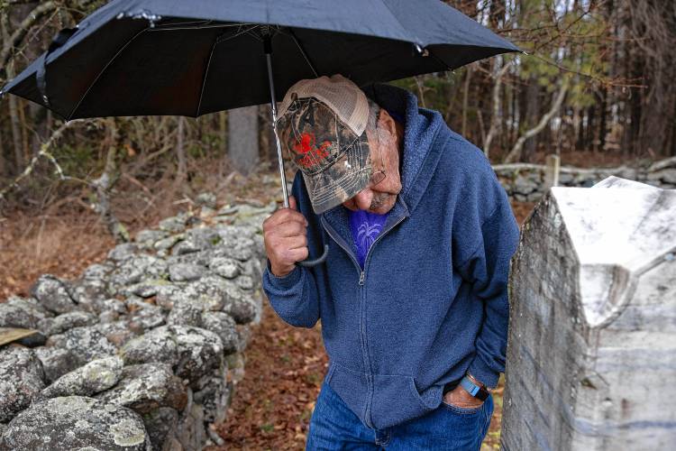 Norm Yeaton looks over the grave marker in the private Yeaton cemetery off of Black Hill Road in Dpsom on Thursday, April 11, 2024. Yeaton has taken on the arduous research project by Yeaton to understand the sheer volume of people in Epsom whose last name was the same as his--even when the name was Yeton before they added the ‘a’ sometime in the 19th century.