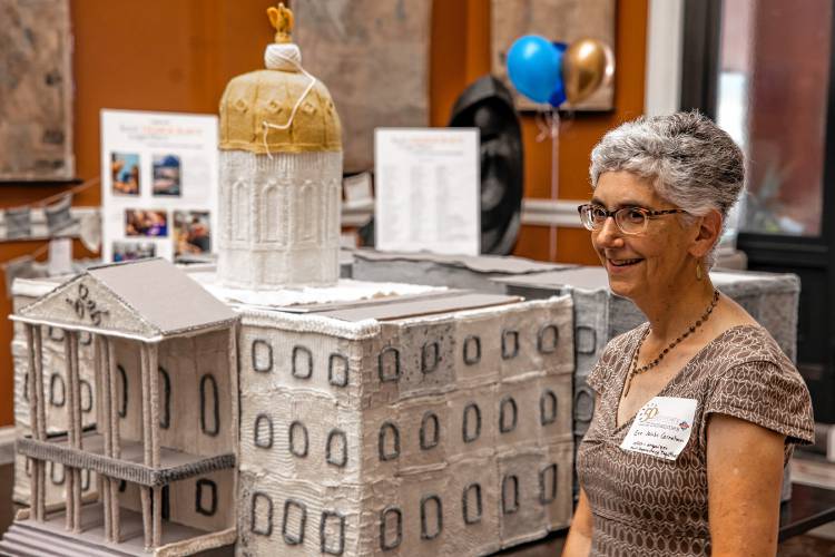 Knit Democracy Together project creator Eve Jacobs-Carnahan shows off the State House knitting model at the New Hampshire State Library on  June 13. The project was part of a initiative from New Hampshire Humanities and the National Endowment for the Humanities.
