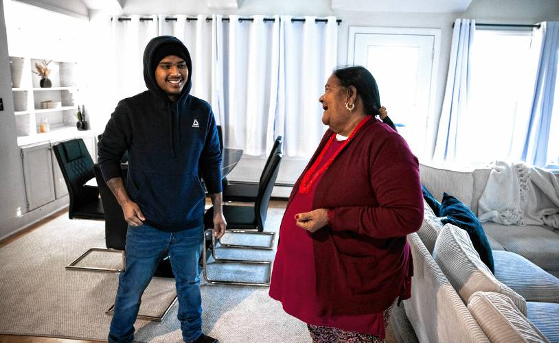 Shamir Darjee (left) and his grandmother, Aiti Darjee, in the living area of his home on Noyes Street in Concord. Darjee recently bought the house and lives there with his family.