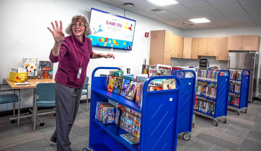 Penacook Library technician Julia Miller waves to a friend during the re-opening of the Penacook Library in its new location at the Community Center.