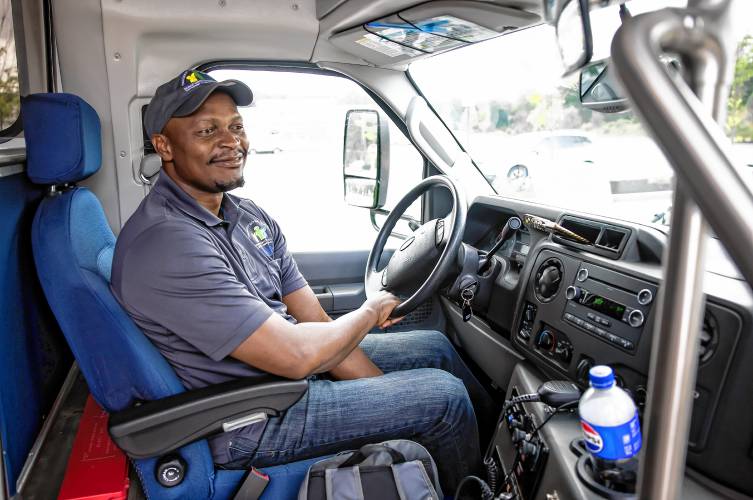 CAT bus driver Morgan Mbuyi waits for riders at the Exit 17 stop near the new Market Basket. Mbuyi was driving up to Franklin that summer day.