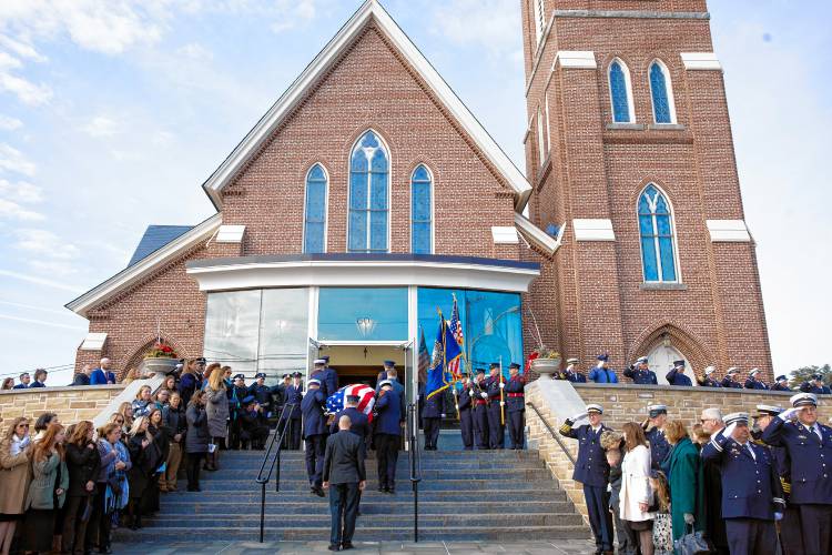 Firefighters from around the state of New Hampshire salute as the casket of Concord firefighter Christopher âCJâ is carried into Christ the King Parish in Concord on Thursday, March 13, 2025.
