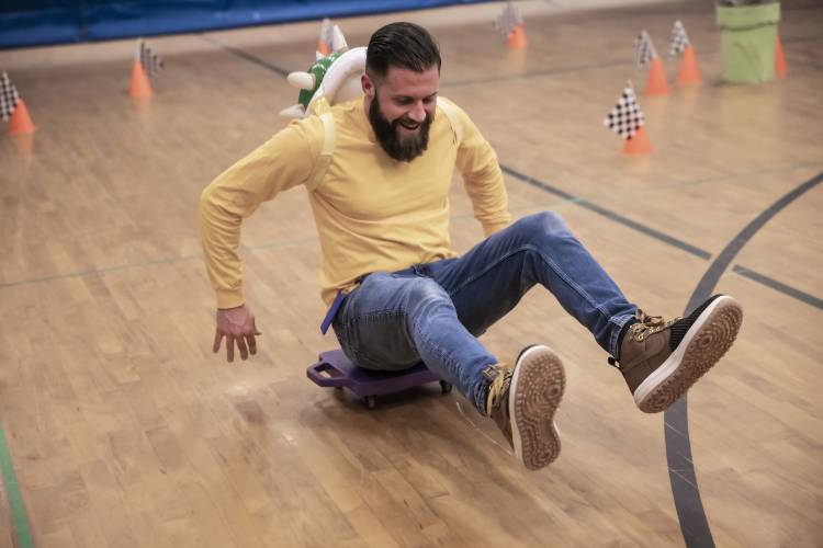 Penacook Elementary School assistant prinicipal Zach Stephenson tries to catch up to student Bailey Flood during a Mario cart race in the school gymnasium on Thursday, March 27, 2025. The Mario Brothers-themed Escape Room included the whole school where students and their families solved mysteries in classrooms and had pizza as well.