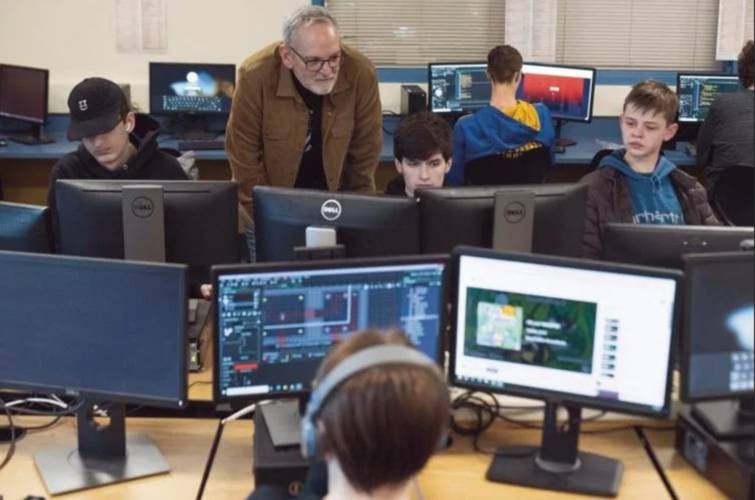 Teacher Aaron Witham helps students in the Video Game Development class at Gilford High School. 