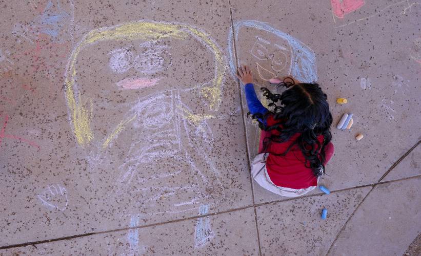 An elementary school student creates chalk art at Frye Elementary School in Chandler, Arizona in 2023.