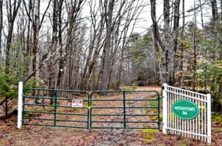 The gate to 386 Meredith Neck Road, formerly the site of Camp Menotomy. The trust that owns the land wishes to sell it to a residential developer, but the state is reviewing the sale to see if deed restrictions were followed.