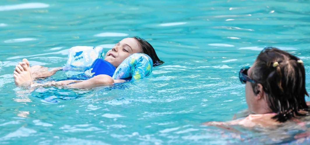 Oliver Friedman holds his feet as he swims in the Garrison Pool on Monday afternoon, as his mother, Danielle Friedman looks on. 