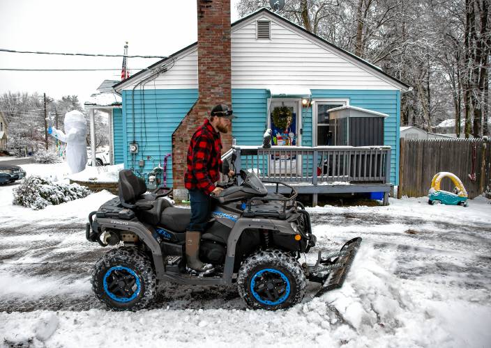 Jonathon Dukette clears his South End driveway using his ATV with a 60” plow on Tuesday morning, December 10, 2024. Another storm with heavy rain is expected on Wednesday.