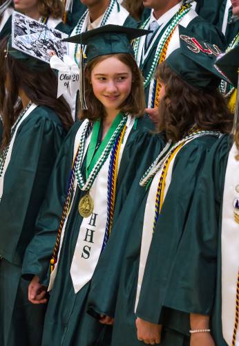 Hopkinton graduate Flo Dapice talks with her friend, Evie Hopper, during the class picture before the graduation on Friday, June 6, 2025.