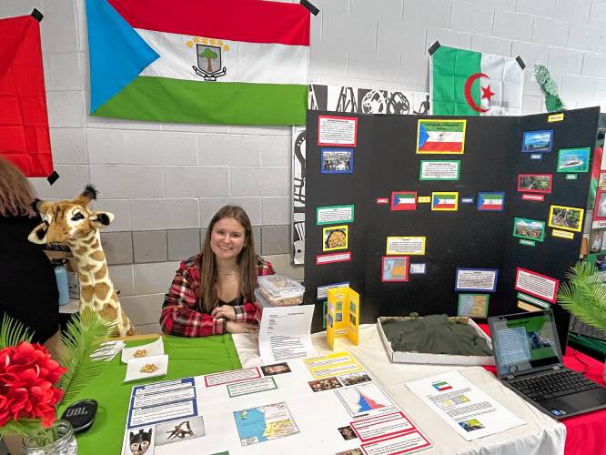 Sophomore Kailyn Gosselin poses with a stuffed giraffe, the official animal of Equatorial Guinea, which she is representing at the World Fair at Bow High School on Friday.