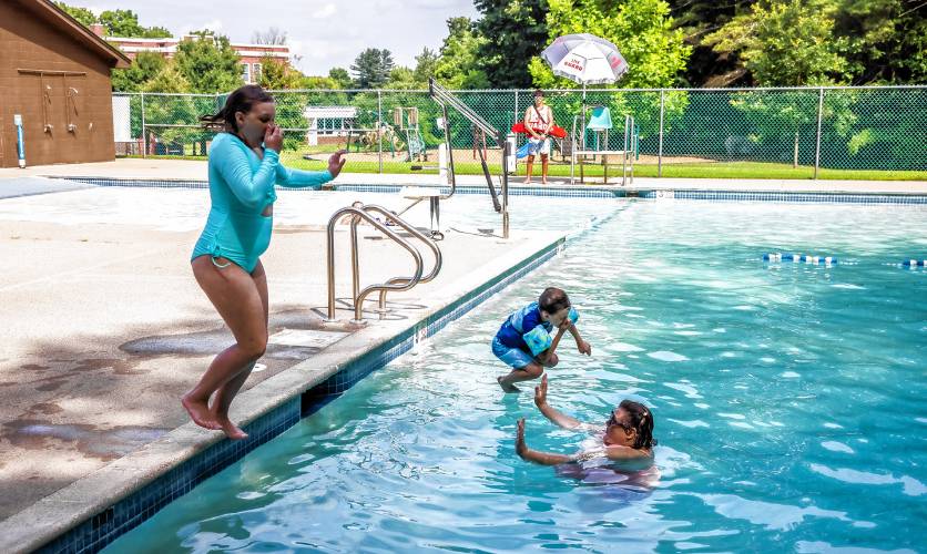 Oliver Friedman (center) and his sister Oliviya Anthony jump in the Garrison Pool on Monday afternoon, as their mother, Danielle Friedman looks on. The city pools are open and fully staffed for the first time in five years.
