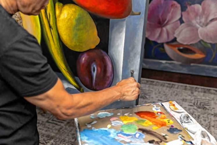 Jay Mercado adds surface texture to the stone border of his fruit still life, which he nicknamed “The Six Amigos,” in his home studio in Jaffrey Tuesday afternoon. Mercado typically doesn’t name his pieces until they are complete.