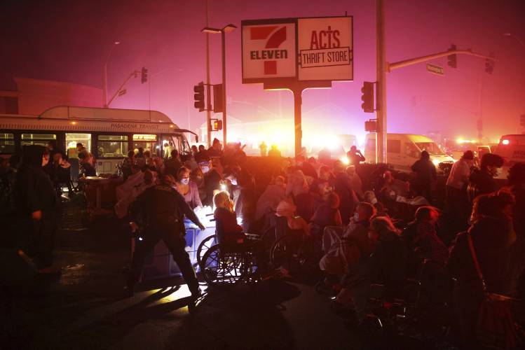 Residents of a senior center are evacuated as the Eaton Fire approaches Tuesday, Jan. 7, 2025 in Altadena, Calif. (AP Photo/Ethan Swope)