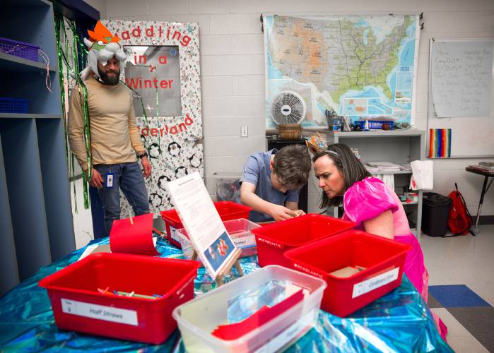 Cooper LeMire (center) and Penacook Elementary School teacher Jaki Egounis AKA Princess Peach work on solving a puzzle as assistant principal Zach Stephenson checks in during the Mario Brothers-themed Escape Room during the family engagement party at the school on Thursday evening, March 27, 2025. 