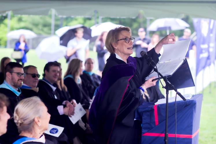 U.S. Sen. Maggie Hassan shows the crowd at the Merrimack Valley graduation her original speech after it got wet during the first downpour at the ceremony on Saturday.