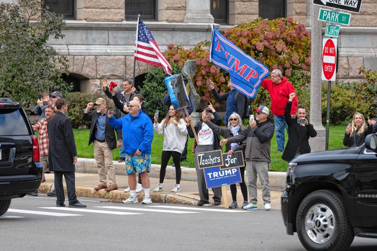 Supporters of former President Donald Trump watch his motorcade as it leaves the New Hampshire Statehouse after Trump signed papers to get on the Republican presidential primary ballot, Monday, Oct. 23, 2023, in Concord, N.H. (AP Photo/Michael Dwyer)