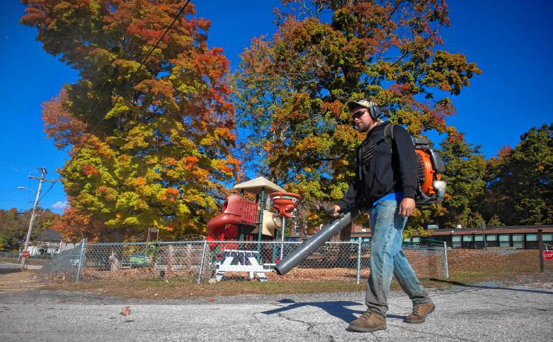 Jay Starkweather of the Kearsarge School District blows leaves in front of the elementary school in downtown Warner, where the Warner Fall Foliage Festival will have vendors put their tents on Wednesday morning.