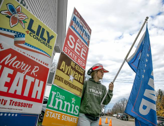 Kaitlyn Lake of Salisbury holds up a Trump sign outside the town hall on Tuesday, November 5, 2024.
