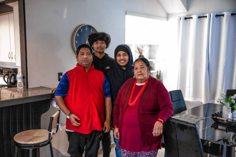 Shamir Darjee (upper right)) and his brother, Sabin, along with his father, Dhan, and his grandmother, Aiti Darjee in the dining area of his home on Noyes Street in Concord. Darjee recently bought the house and lives there with his family.