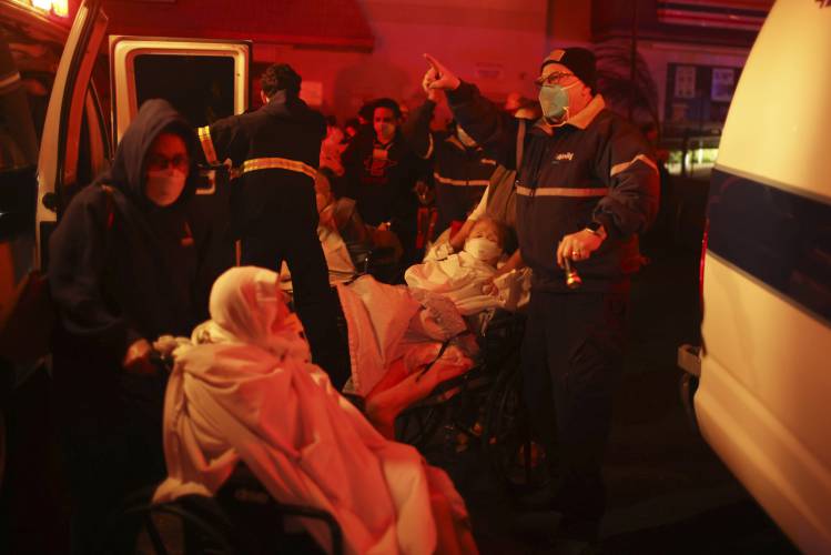 Residents of a senior center are evacuated as the Eaton Fire approaches Tuesday, Jan. 7, 2025 in Altadena, Calif. (AP Photo/Ethan Swope)