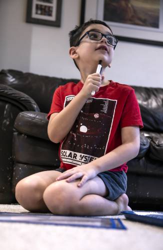 Greyson LeGeyt works on an addition game in the family living room on January 9, 2025.