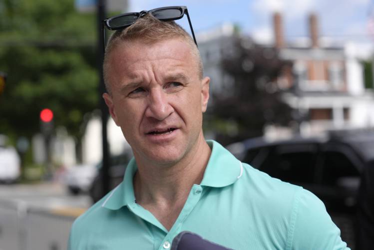 Aidan Timothy Kearney speaks with a reporter outside Norfolk Superior Court, Monday, July 1, 2024, in Dedham, Mass. Kearney, a blogger, has posted articles critical of the prosecution in the Karen Read case. A judge declared a mistrial Monday after jurors deadlocked in the case of Read, who was accused of killing her Boston police officer boyfriend by striking him with her SUV and leaving him in a snowstorm. (AP Photo/Steven Senne)