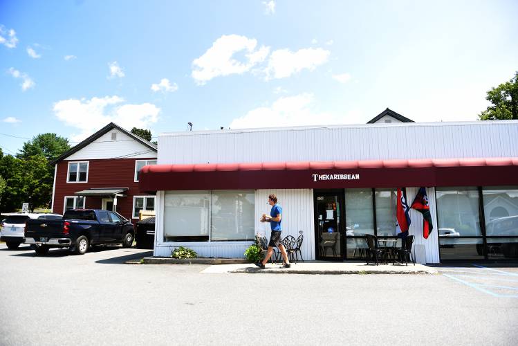 Cole Dunbar, of West Lebanon, leaves the The Karibbean with takeout food on Friday. Dunbar has recently moved to the area and said he was “super excited about the culinary diversity,” saying he had come from a place that had less to offer like burgers, beer and milkshakes.