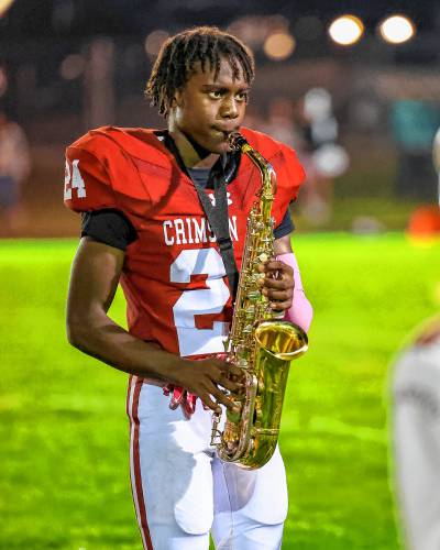 Ramon Reynolds playing the saxophone at halftime while the rest of the team goes into the locker room to game-plan.