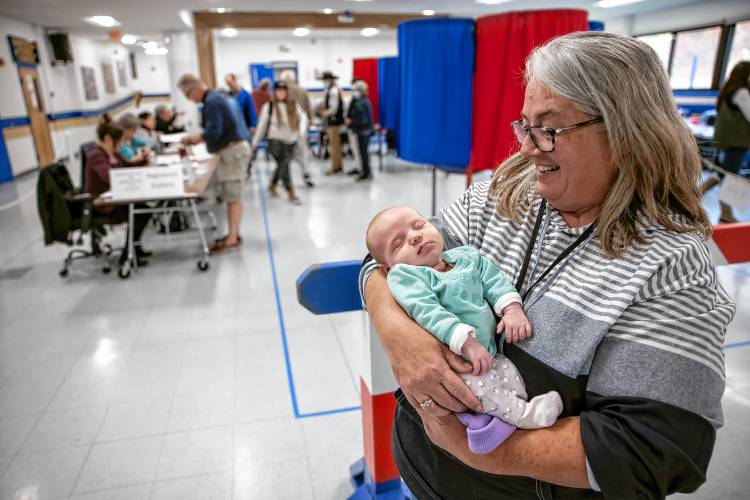 Franklin Supervisor of the Checklist for Ward Two Tina Nelson holds her tweltth grandchild, Coraline Nelson, as her daughter-in-law votes at Franklin High School on Tuesday, November 5, 2024.