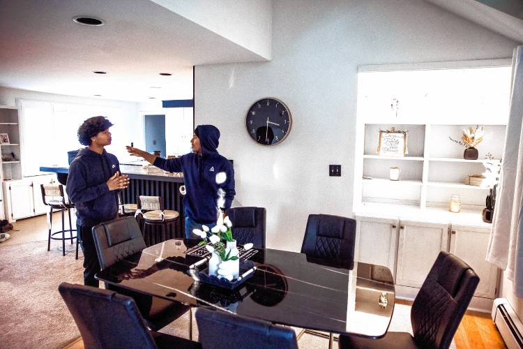 Shamir Darjee (right) and his brother, Sabin, in the dining area of his home on Noyes Street in Concord.