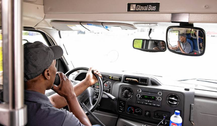 CAT bus driver Morgan Mbuyi talks on the radio before heading toward Franklin on a morning in July.