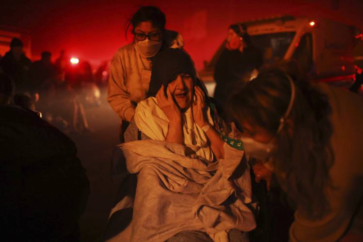 A resident of a senior center is evacuated as the Eaton Fire approaches Tuesday, Jan. 7, 2025 in Altadena, Calif. (AP Photo/Ethan Swope)