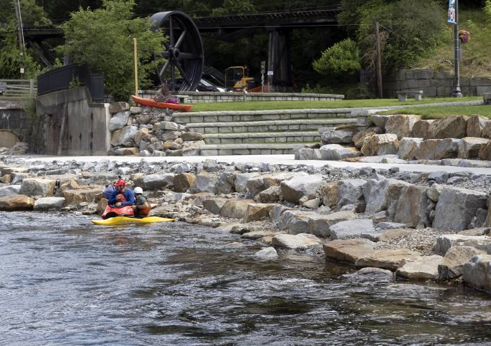 Friends Matt Thibault of Gorham, Maine (left) and David Plizga of Portland, Maine take a break in the pool area of the new Mill City Park at Franklin Falls in downtown Franklin on Tuesday, July 26, 2022. The pair drove the two hours to experience the new competition hole, a manmade structure that creates a wave with a deep pool on downward side where kayakers can practice their moves in safety and in low water situations.