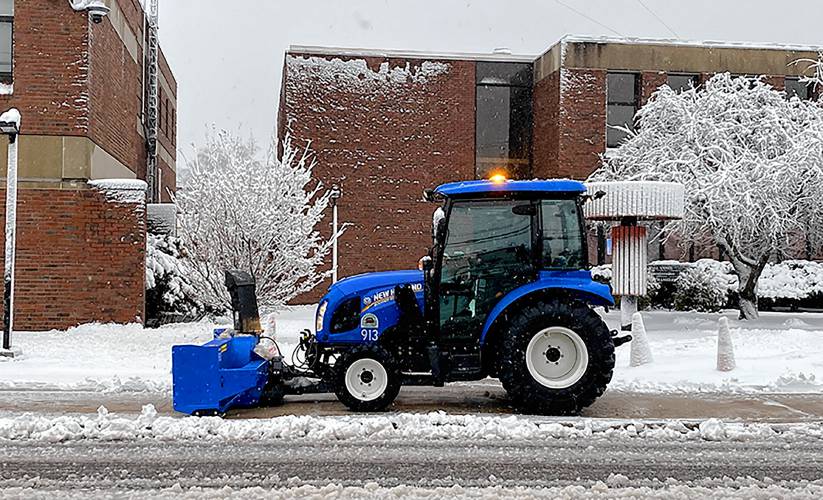 A city tractor with a snowblower attachment clears the sidewalk in front of the City Hall complex on Green Street on Thursday morning, April 4, 2024.