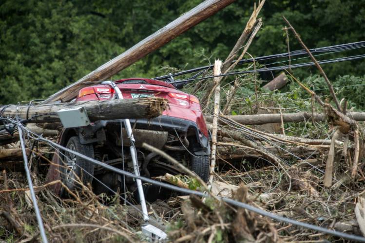 A damaged car sits amid flood debris in Lyndon, Vt., Tuesday, July 30, 2024. (AP Photo/Dmitry Belyakov)